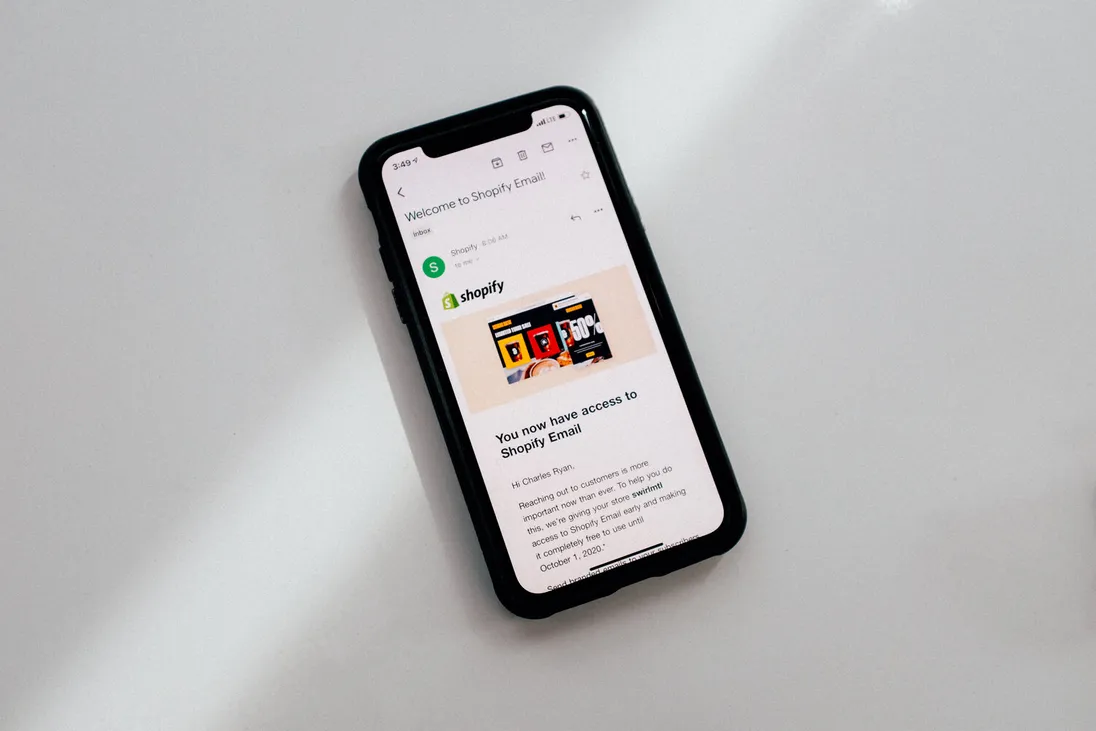 Smartphone met een welkomstmail van Shopify Email op het scherm